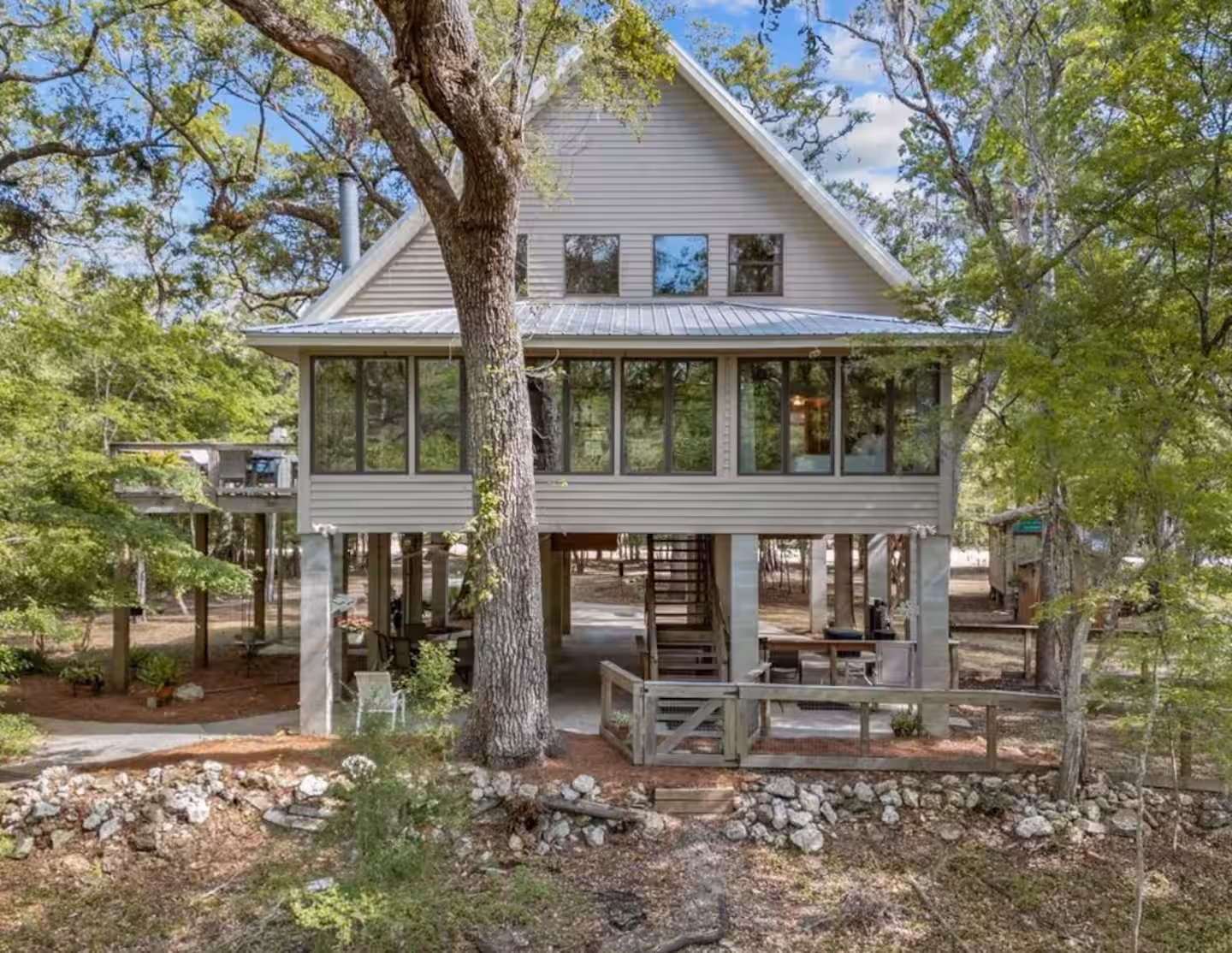The elevated riverfront house with screened porch and covered parking below